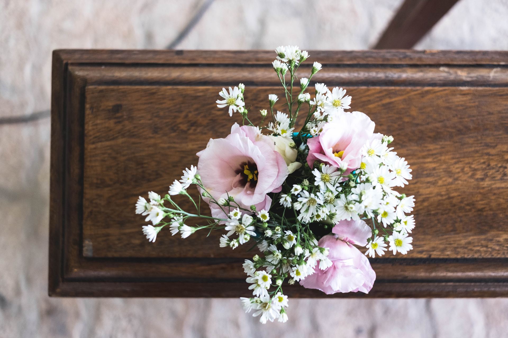 a vase filled with flowers sitting on top of a wooden table