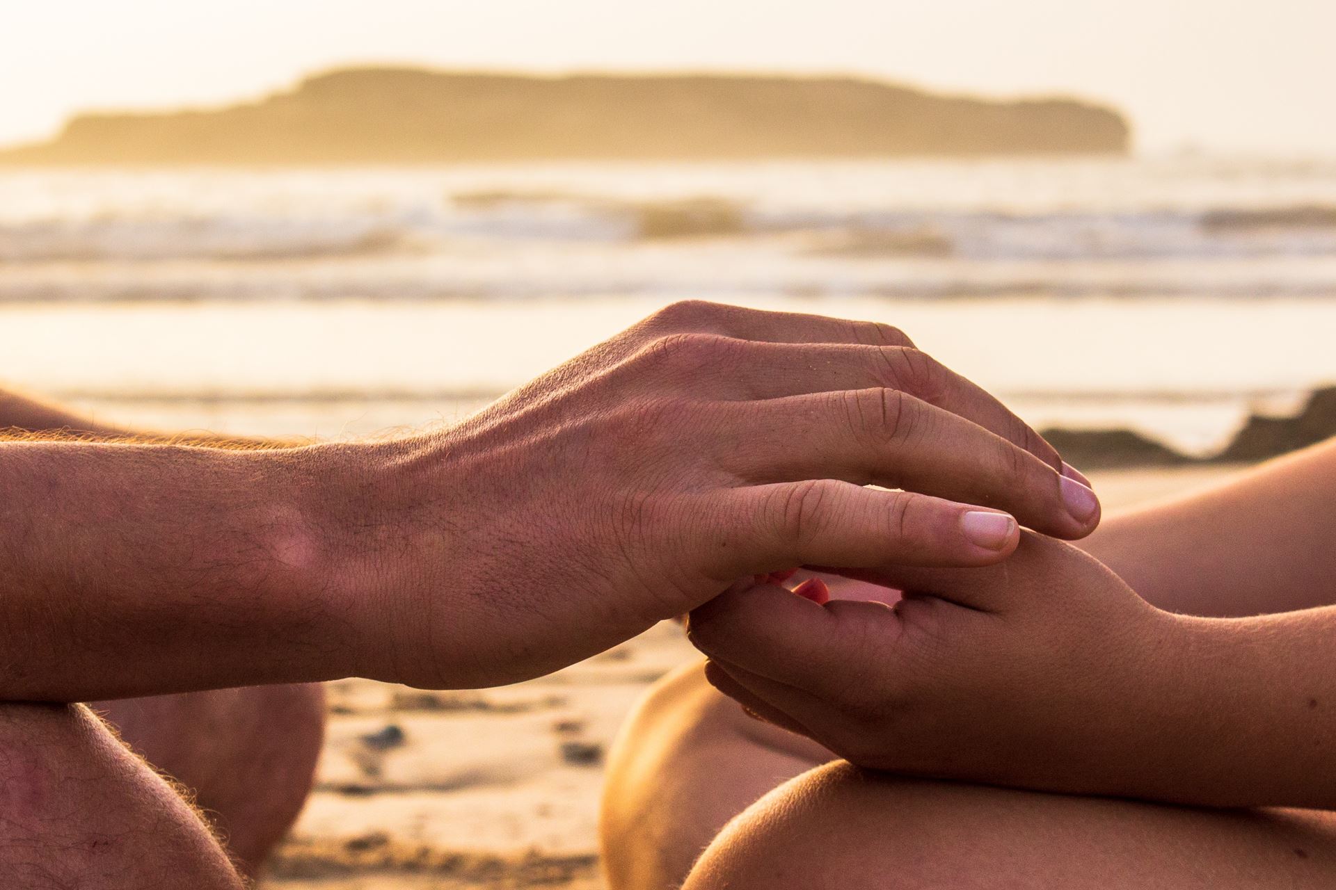 a close up of a person sitting on a beach